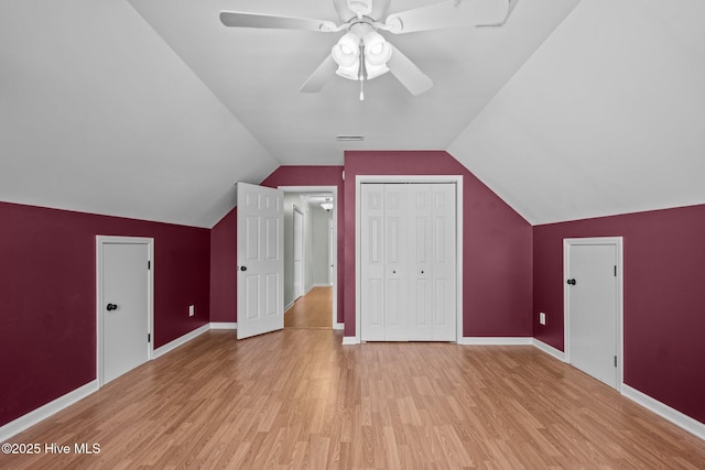 bonus room featuring light wood finished floors, baseboards, vaulted ceiling, and a ceiling fan