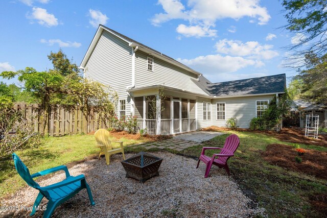 back of property featuring an outdoor fire pit, a patio area, fence, and a sunroom