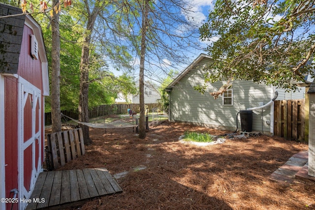 view of yard with a storage shed, an outdoor structure, and fence
