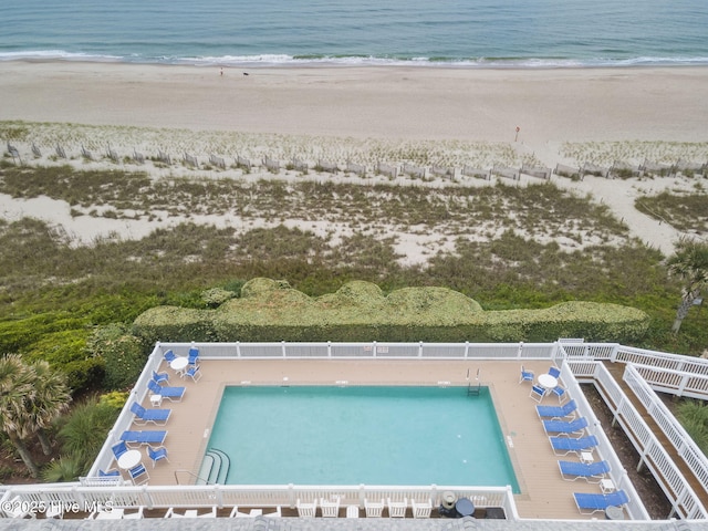 birds eye view of property with a water view and a beach view
