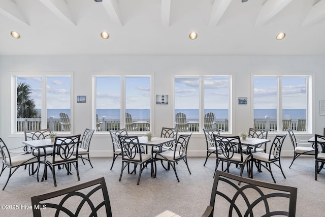 dining space with recessed lighting, vaulted ceiling with beams, light carpet, and a healthy amount of sunlight