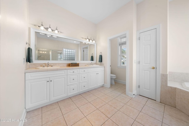 full bath featuring toilet, a stall shower, a sink, and tile patterned floors