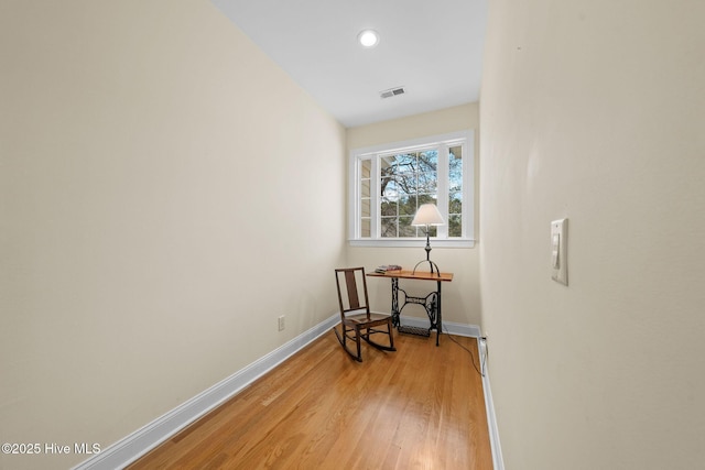 hall featuring light wood-style flooring, baseboards, visible vents, and recessed lighting