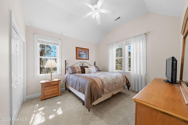 bedroom featuring light carpet, multiple windows, lofted ceiling, and visible vents