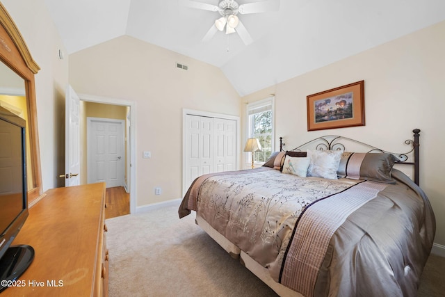 bedroom featuring a closet, a ceiling fan, visible vents, light carpet, and lofted ceiling