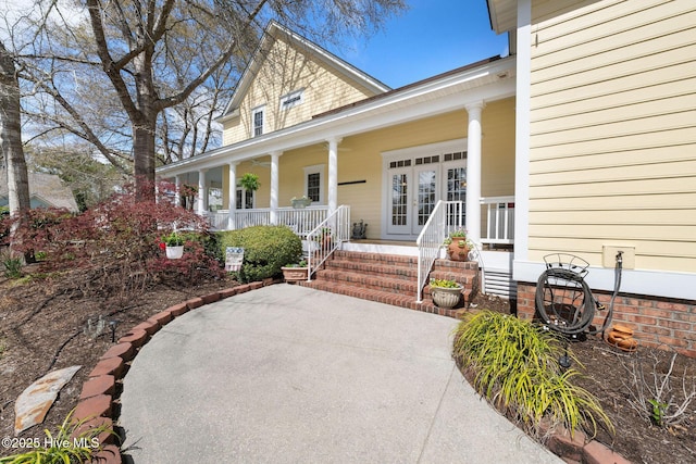 view of exterior entry featuring french doors and covered porch