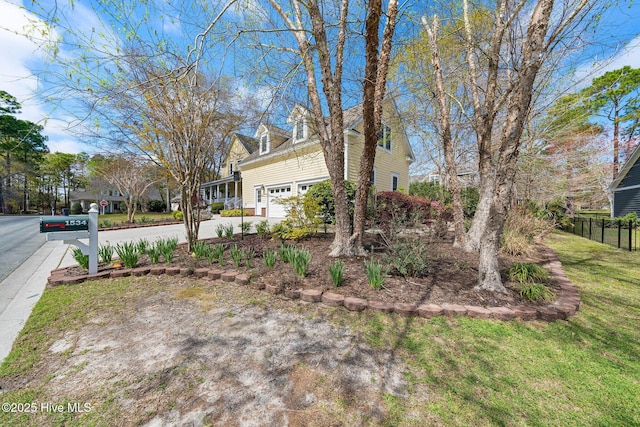 exterior space featuring concrete driveway, a garage, and a front yard