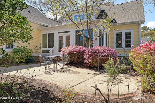 rear view of house featuring a patio, roof with shingles, and french doors