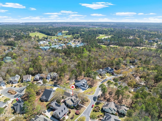 drone / aerial view featuring a wooded view and a residential view