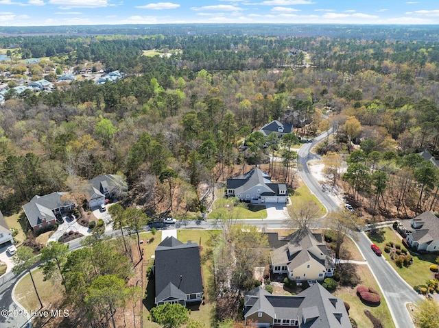 drone / aerial view with a wooded view and a residential view