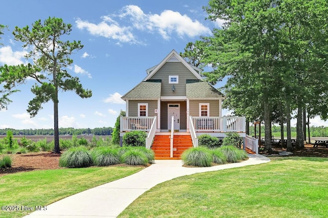 view of front of home featuring a front yard, stairway, and covered porch