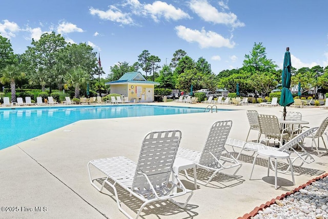 pool with a patio area and fence