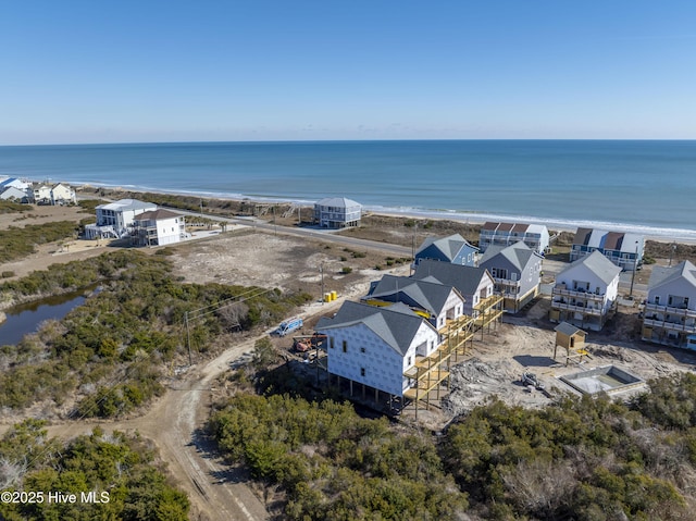 birds eye view of property featuring a water view and a beach view