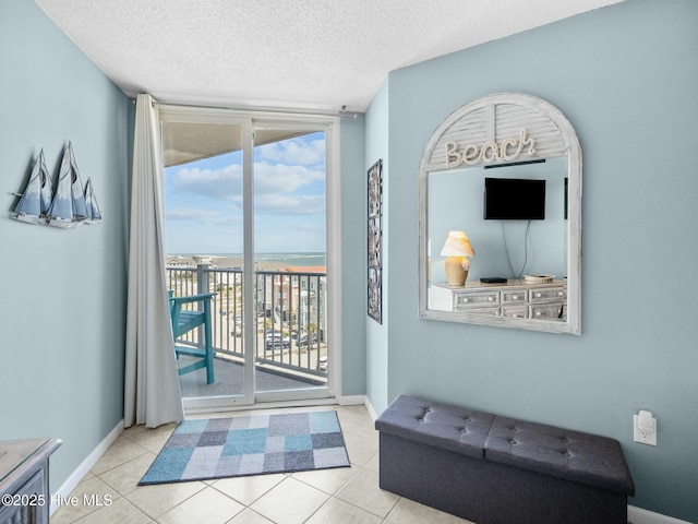 2000 New River Inlet Rd Unit 3513, North Topsail Beach, NC 28460 - doorway with expansive windows, tile patterned floors, baseboards, and a textured ceiling