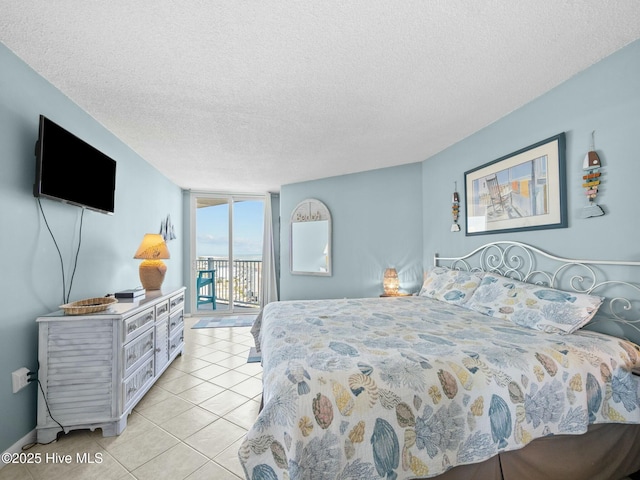 2000 New River Inlet Rd Unit 3513, North Topsail Beach, NC 28460 - bedroom with floor to ceiling windows, light tile patterned floors, access to outside, and a textured ceiling