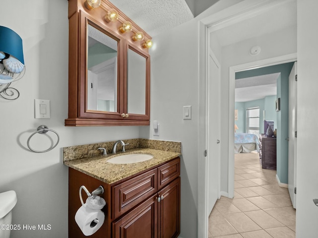 2000 New River Inlet Rd Unit 3513, North Topsail Beach, NC 28460 - bathroom featuring baseboards, toilet, a textured ceiling, vanity, and tile patterned floors
