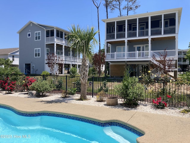 view of swimming pool featuring a fenced in pool, fence, and a sunroom