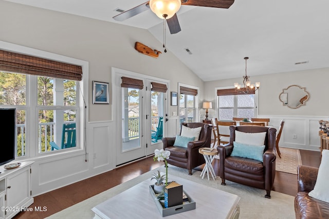 living area featuring a healthy amount of sunlight, a decorative wall, wood finished floors, and a wainscoted wall