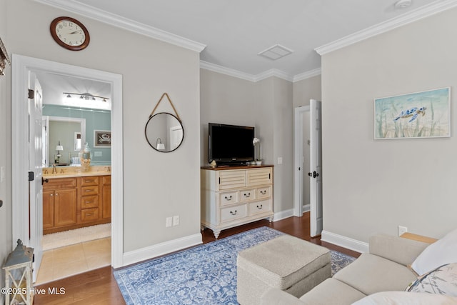 living area featuring baseboards, ornamental molding, and wood finished floors