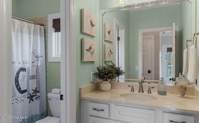 full bathroom with a wealth of natural light, curtained shower, vanity, and toilet