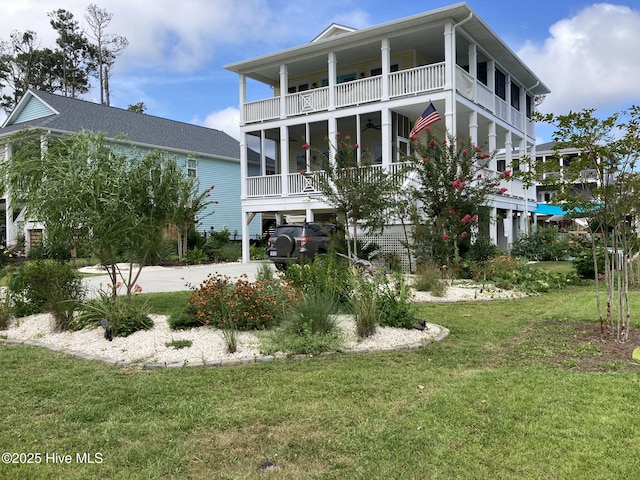 back of house with a yard, covered porch, and a balcony