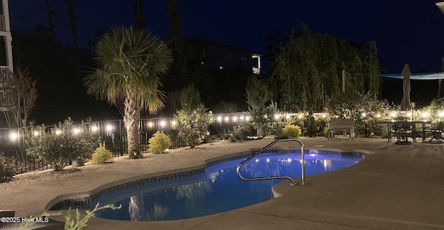 pool at twilight with a fenced in pool, a patio, and a fenced backyard
