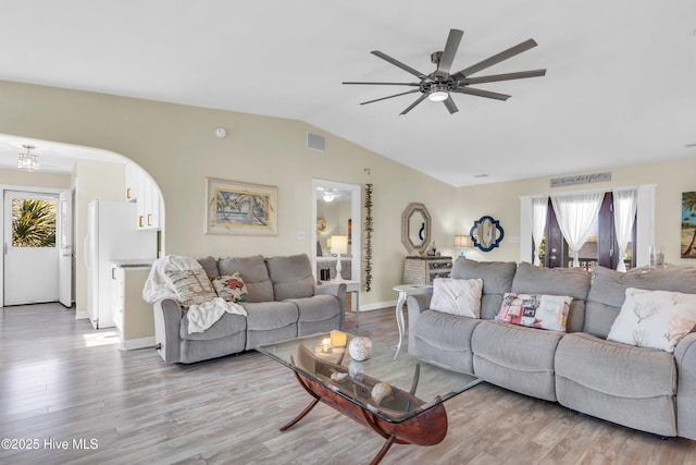 living area featuring visible vents, wood finished floors, lofted ceiling, baseboards, and a ceiling fan