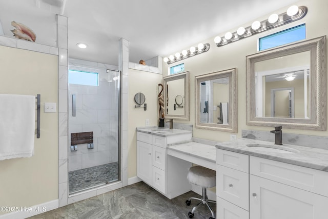 bathroom featuring vanity, baseboards, marble finish floor, and a stall shower