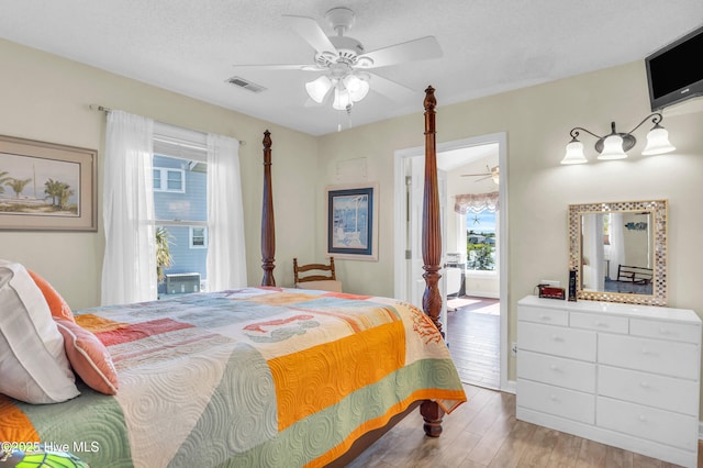 bedroom featuring ceiling fan, ensuite bath, light wood-style flooring, and visible vents