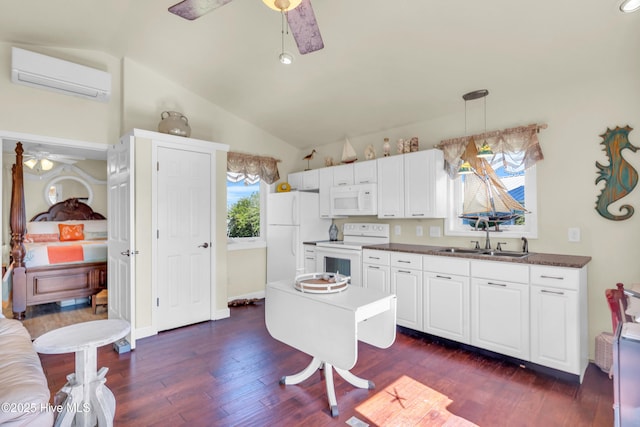 kitchen featuring white appliances, an AC wall unit, ceiling fan, and a sink