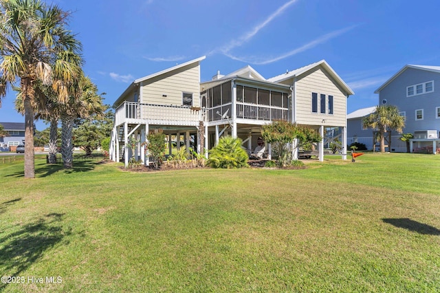 back of property with a sunroom, a lawn, and stairs
