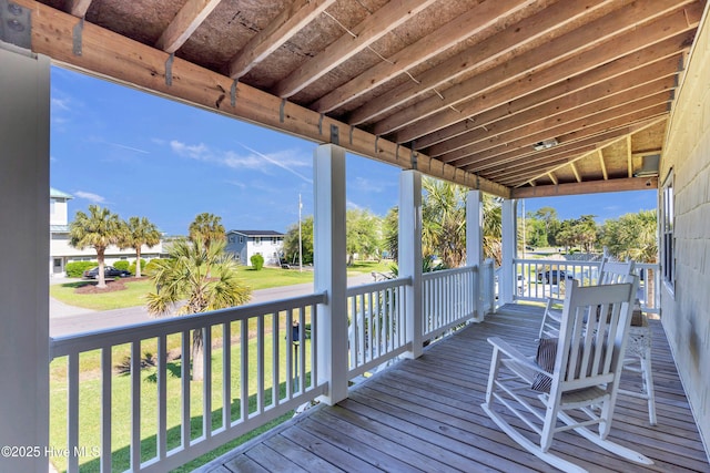 wooden deck featuring a lawn and a porch