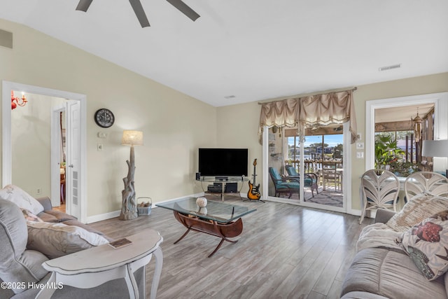 living room featuring visible vents, a ceiling fan, baseboards, and wood finished floors