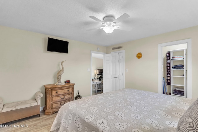 bedroom with visible vents, a ceiling fan, wood finished floors, and a closet