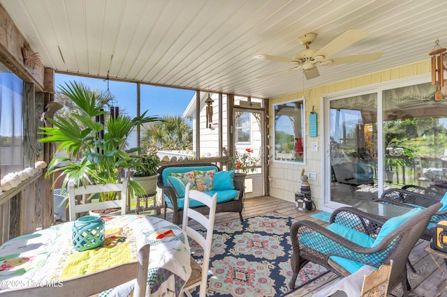 sunroom / solarium featuring ceiling fan and an outdoor living space