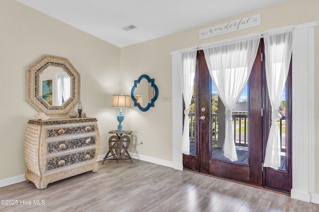 entrance foyer with baseboards, wood finished floors, visible vents, and french doors