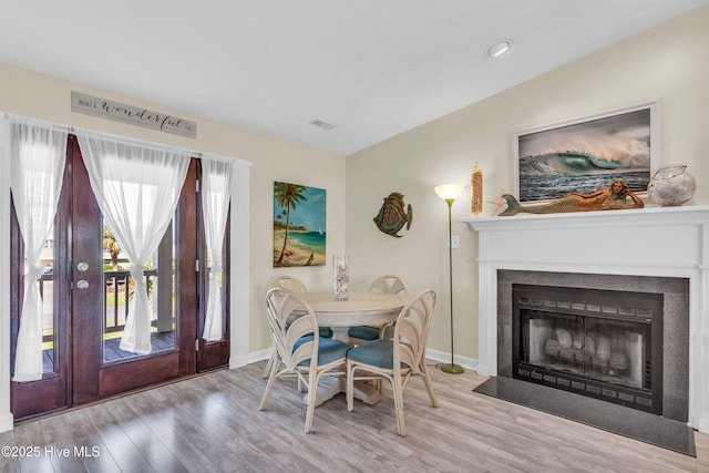 dining room featuring baseboards, wood finished floors, and a fireplace