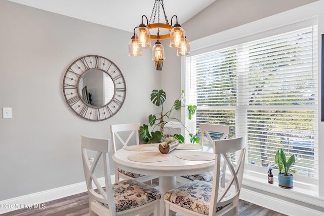 107 SW 25th St, Oak Island, NC 28465 - dining space featuring baseboards, a notable chandelier, a healthy amount of sunlight, and wood finished floors