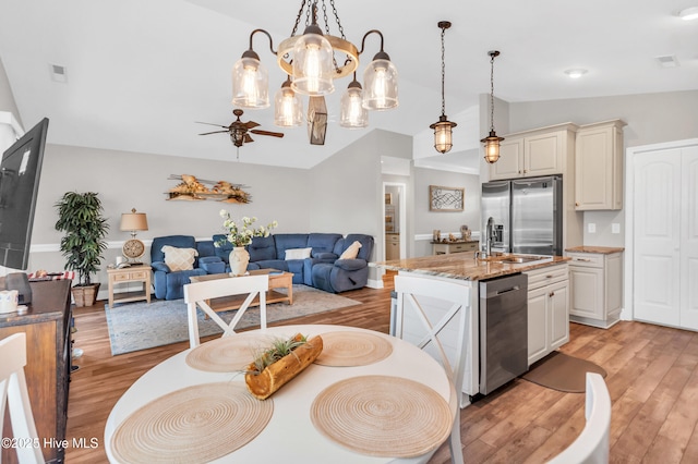 107 SW 25th St, Oak Island, NC 28465 - dining room featuring light wood-style flooring, lofted ceiling, and ceiling fan with notable chandelier