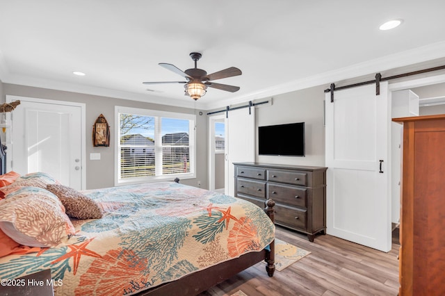 107 SW 25th St, Oak Island, NC 28465 - bedroom with crown molding, wood finished floors, a barn door, and recessed lighting