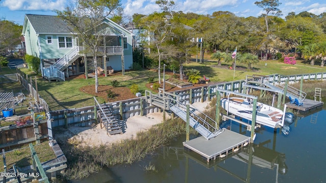 107 SW 25th St, Oak Island, NC 28465 - dock area with stairway, boat lift, a yard, view of wooded area, and a deck with water view