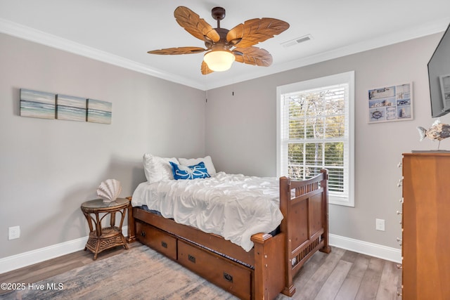 107 SW 25th St, Oak Island, NC 28465 - bedroom with ornamental molding, baseboards, visible vents, and wood finished floors