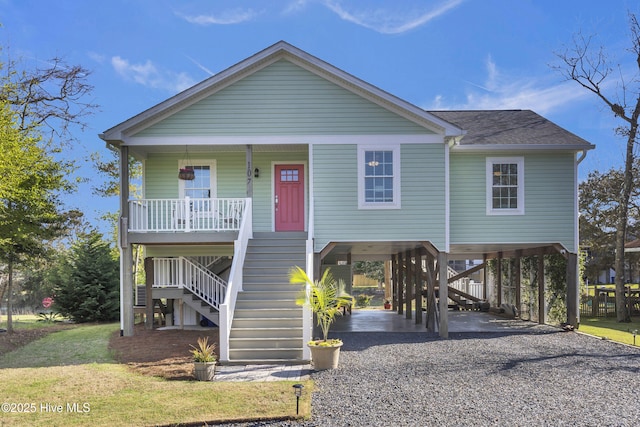 107 SW 25th St, Oak Island, NC 28465 - beach home with a carport, covered porch, stairway, gravel driveway, and a shingled roof
