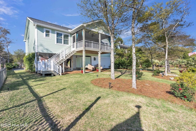 107 SW 25th St, Oak Island, NC 28465 - back of property with a yard, stairs, and a sunroom