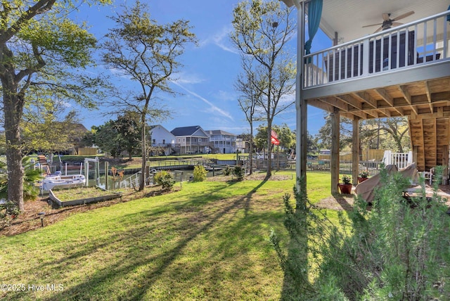 107 SW 25th St, Oak Island, NC 28465 - view of yard with fence, a vegetable garden, a ceiling fan, and a residential view