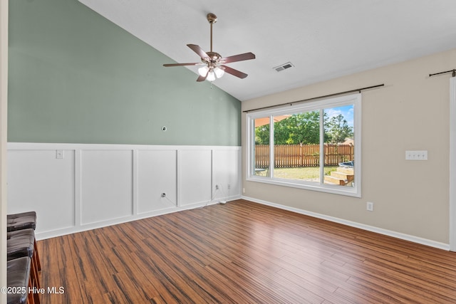 empty room featuring visible vents, wood finished floors, a ceiling fan, and lofted ceiling