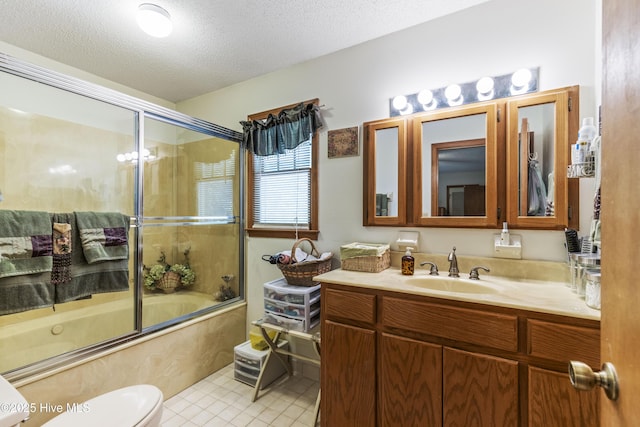 bathroom with tile patterned floors, a textured ceiling, vanity, enclosed tub / shower combo, and toilet