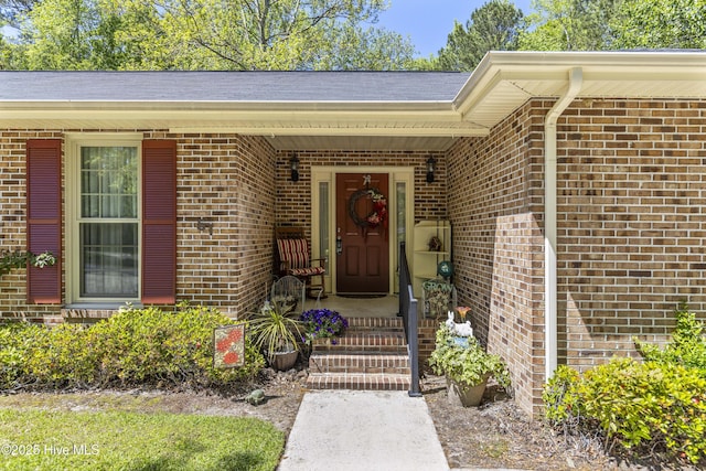 entrance to property featuring brick siding