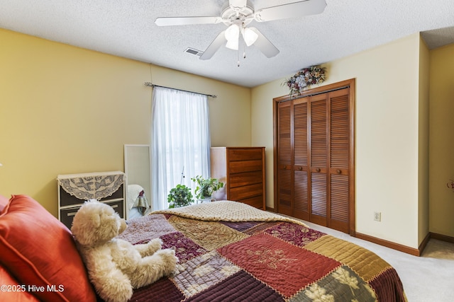 bedroom with visible vents, carpet floors, a closet, a textured ceiling, and ceiling fan