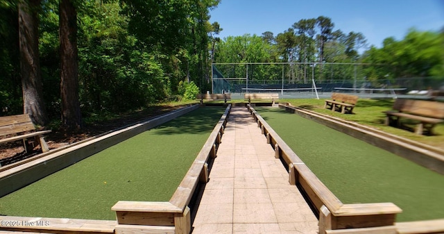 view of community featuring fence and a tennis court
